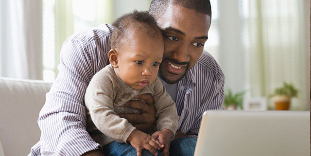 Man with his baby boy typing on a laptop